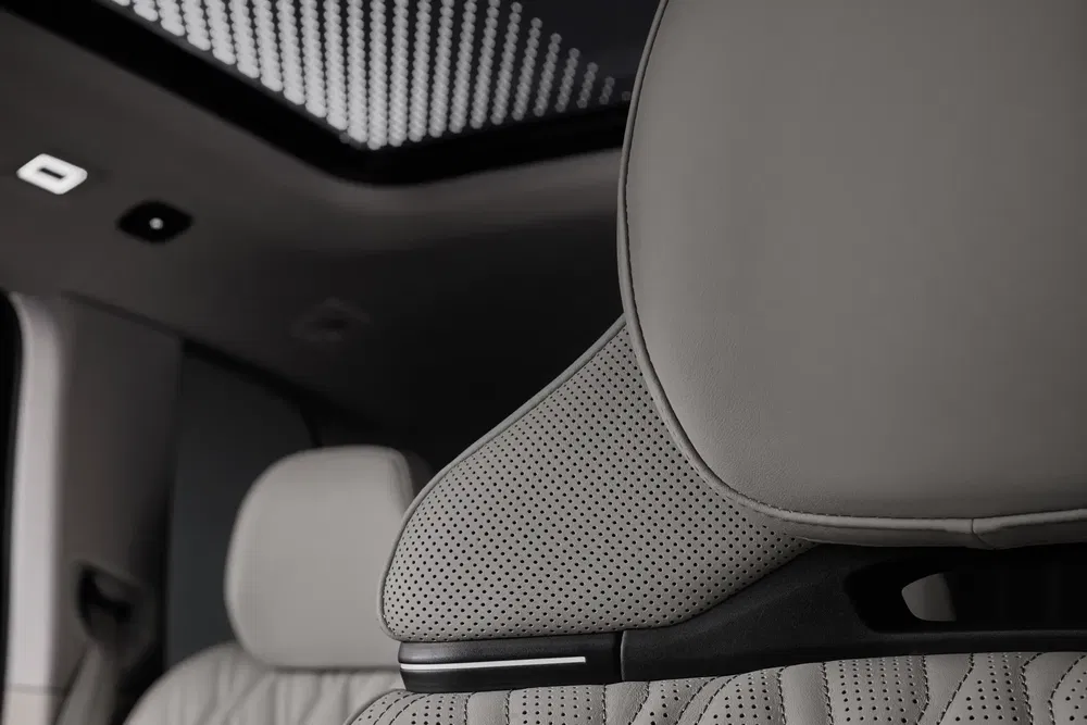 Intérieur luxueux de voiture avec appuie-tête en cuir perforé et toit panoramique moderne.