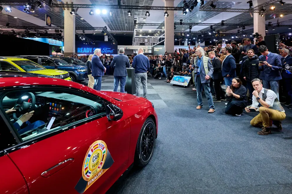 {"fr":"Salon automobile avec modèle Ford rouge finaliste du concours de la voiture de l'année.","nl":"Autosalon met rode Ford finalist voor de auto van het jaar competitie."}