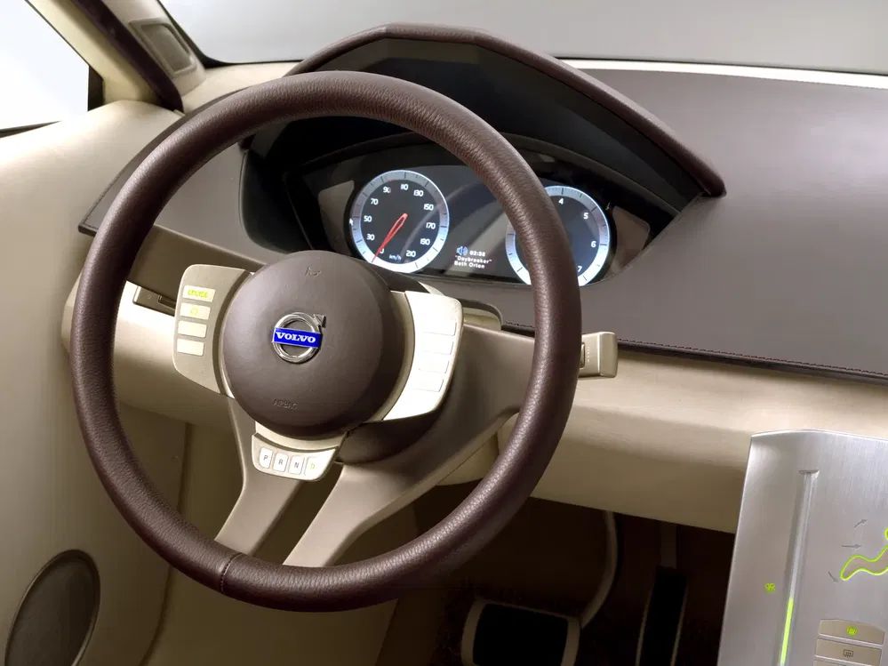 Volvo-stuurwiel met modern dashboard en digitale snelheidsmeter.