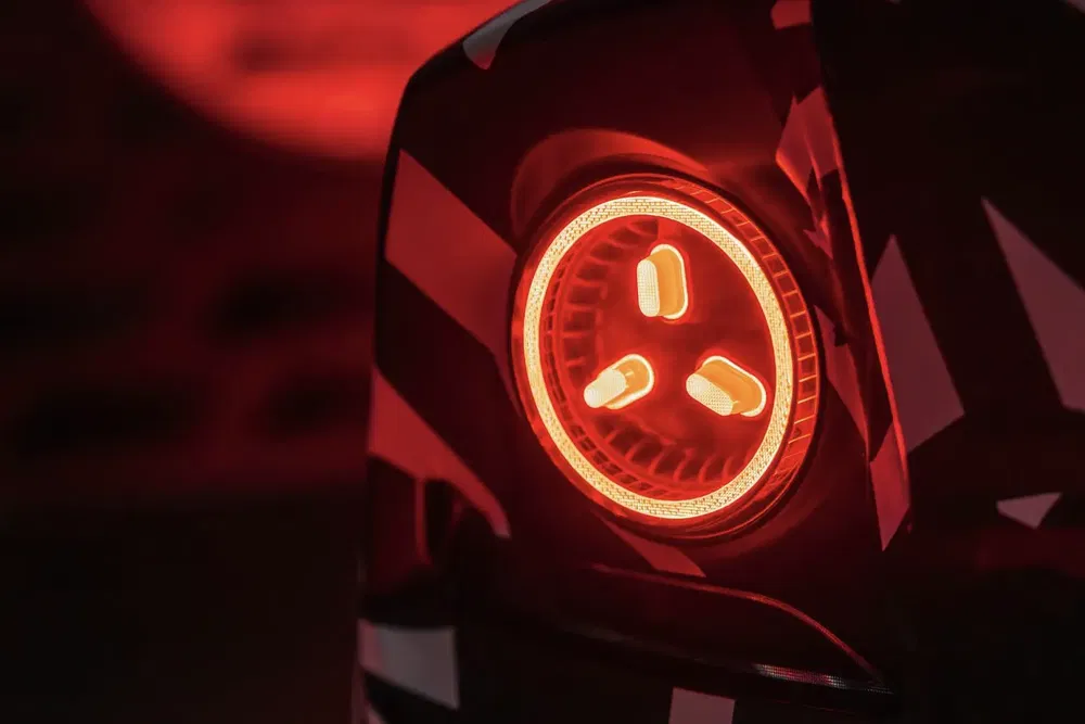 Feu arrière circulaire lumineux d'une voiture moderne en rouge intense.