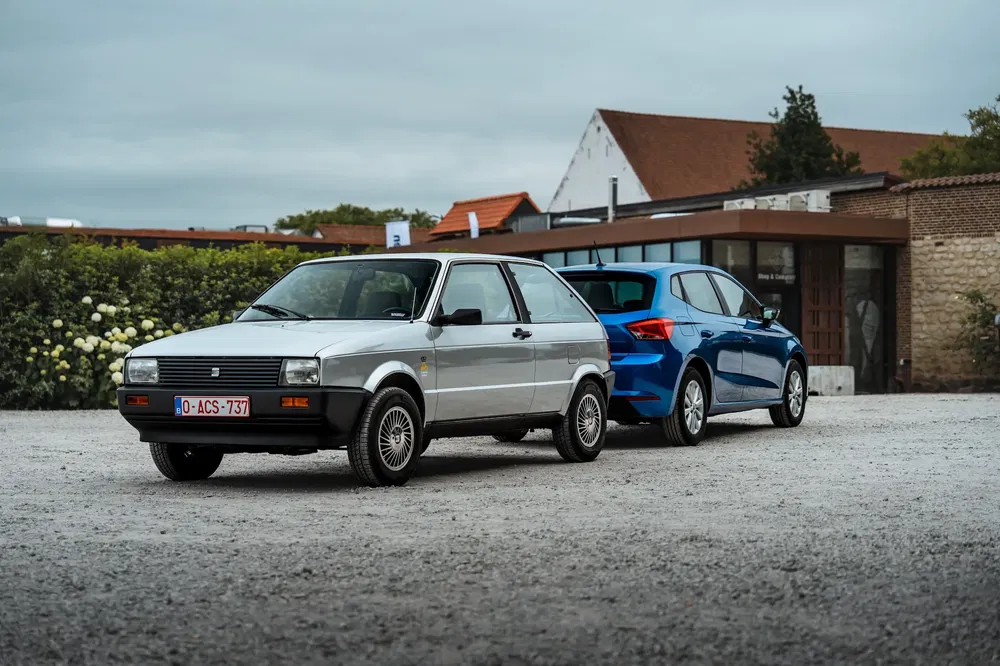 {"fr":"Deux voitures garées, une ancienne modèle vintage, une moderne bleue, devant un bâtiment.","nl":"Twee auto's geparkeerd, een vintage model en een moderne blauwe, voor een gebouw."}