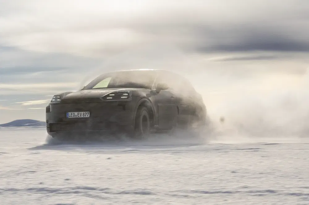 Porsche Macan électrique traversant la neige, démontrant ses capacités de conduite hivernale.