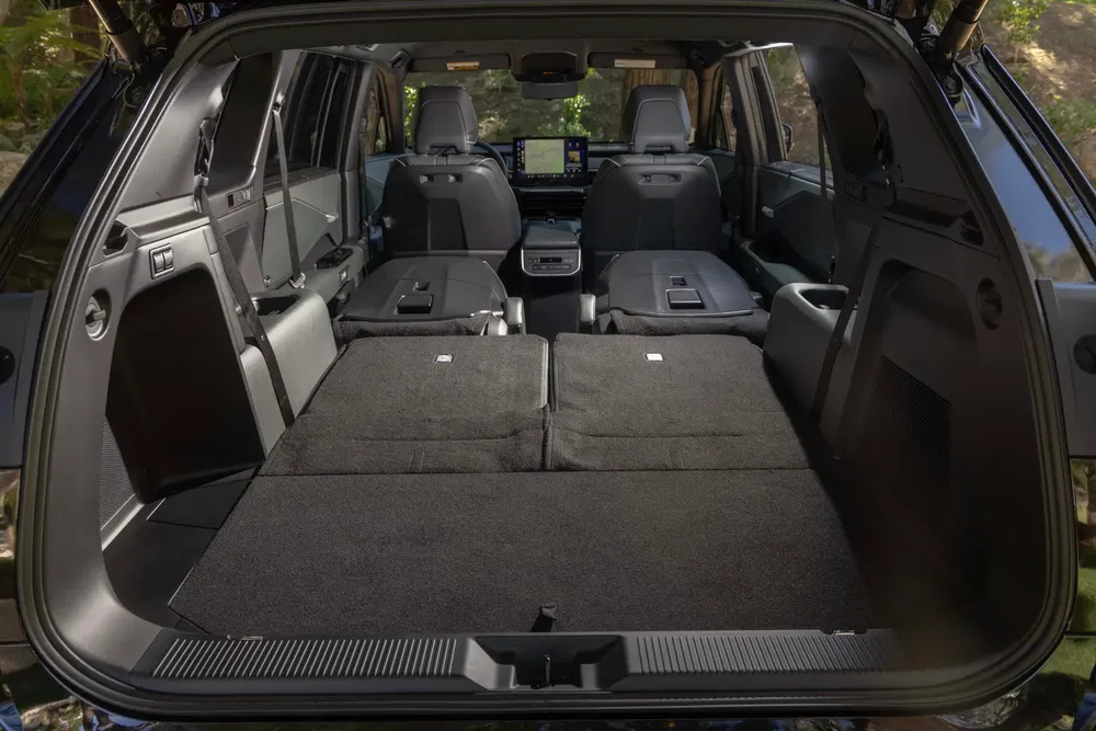 Intérieur spacieux du Toyota Land Cruiser, sièges arrière rabattus pour maximiser l'espace de chargement.