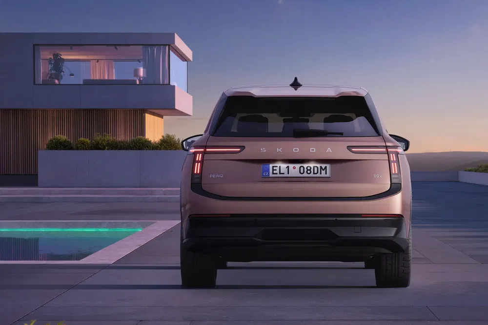 Vue arrière du SUV Škoda, stationné devant une maison moderne au crépuscule.