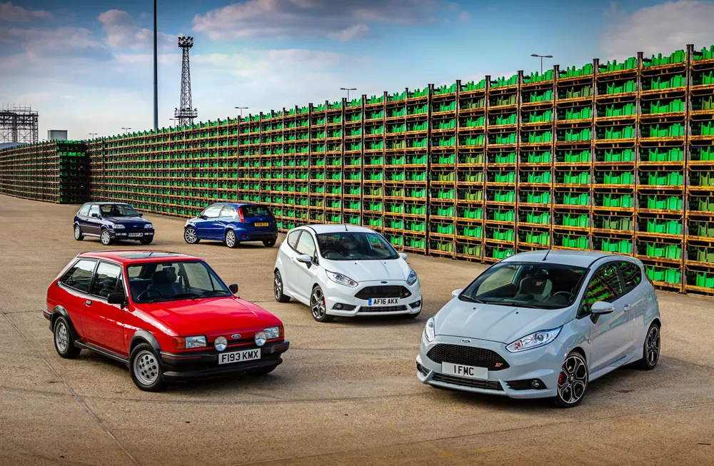 Moderne en oude Ford Fiesta's opgesteld voor groene transportkisten.