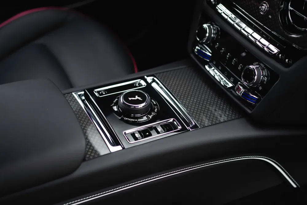 Console centrale de luxe d'une Rolls-Royce avec commandes en chrome et finitions en cuir.