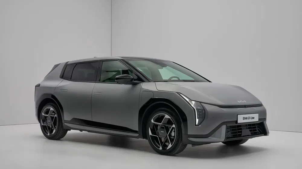 Kia EV4 grise en studio, design moderne et aérodynamique, jantes en alliage distinctives.