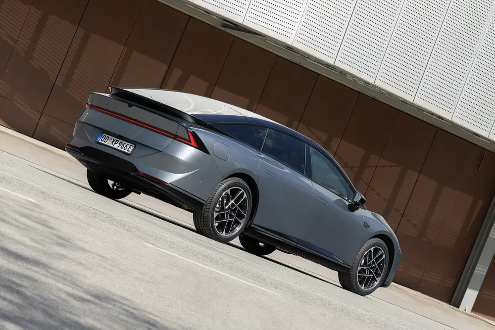 Peugeot 508 gris, design futuriste, garée devant un mur moderne.