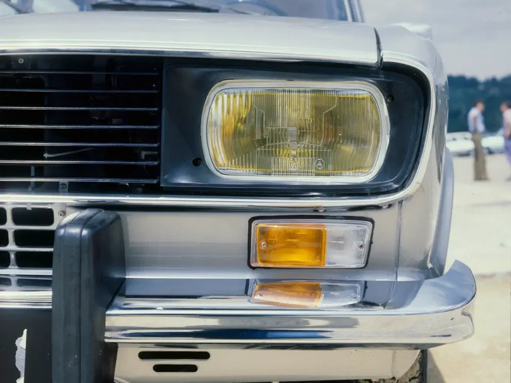 Gros plan sur le phare avant droit d'une Dacia 1300 en argent classique.