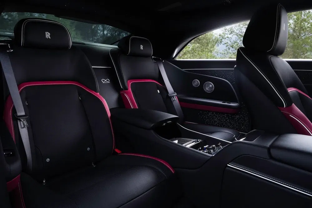 Intérieur luxueux de Rolls-Royce avec sièges en cuir noir et accents rouges élégants.