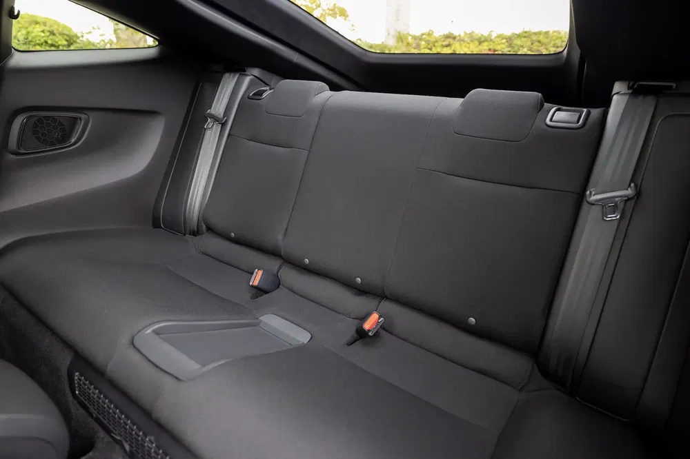 Achterstoelen van een moderne sportwagen met zichtbare veiligheidsgordels.