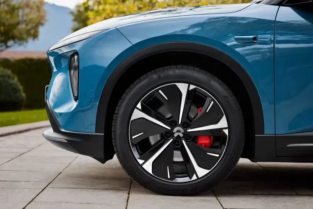 Zijaanzicht van een NIO elektrische auto met stijlvolle lichtmetalen velg.