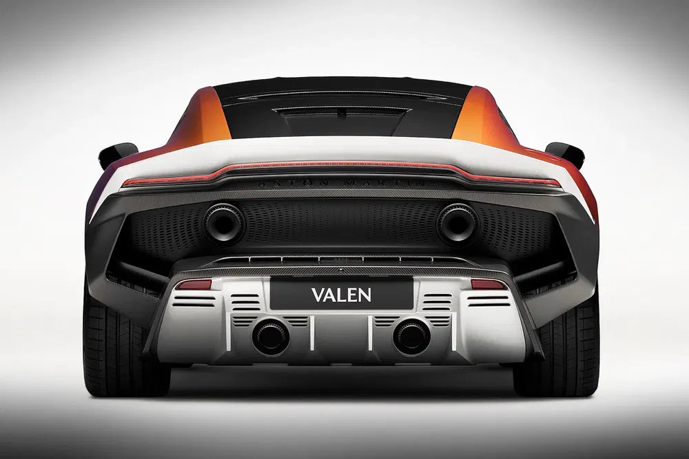 Vue arrière d'une supercar Orange Valen avec double échappement sur fond blanc.