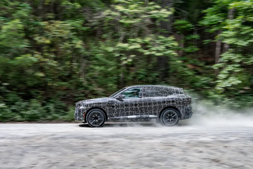 SUV gehuld in camouflage, snel off-road testen op bospad.