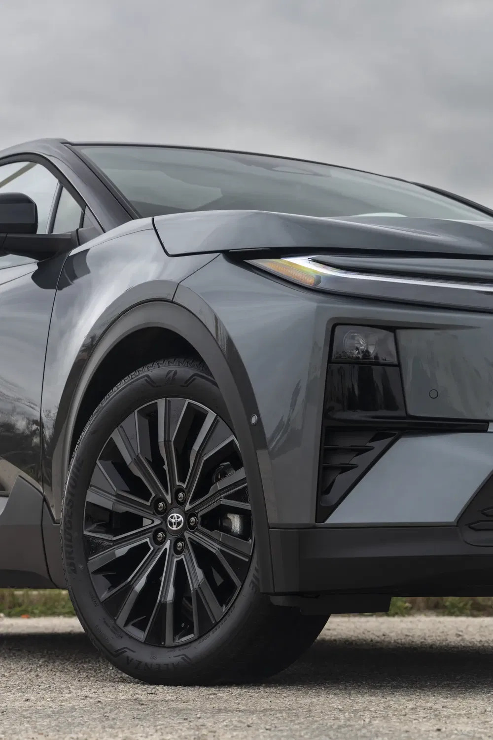 Voorwielen en koplamp van de Toyota C-HR 2024, modern ontwerp en sportieve elegantie.