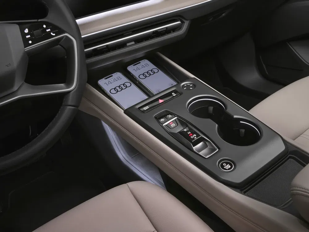 Intérieur d'une Audi avec smartphone intégré et commandes numériques modernes sur la console centrale.