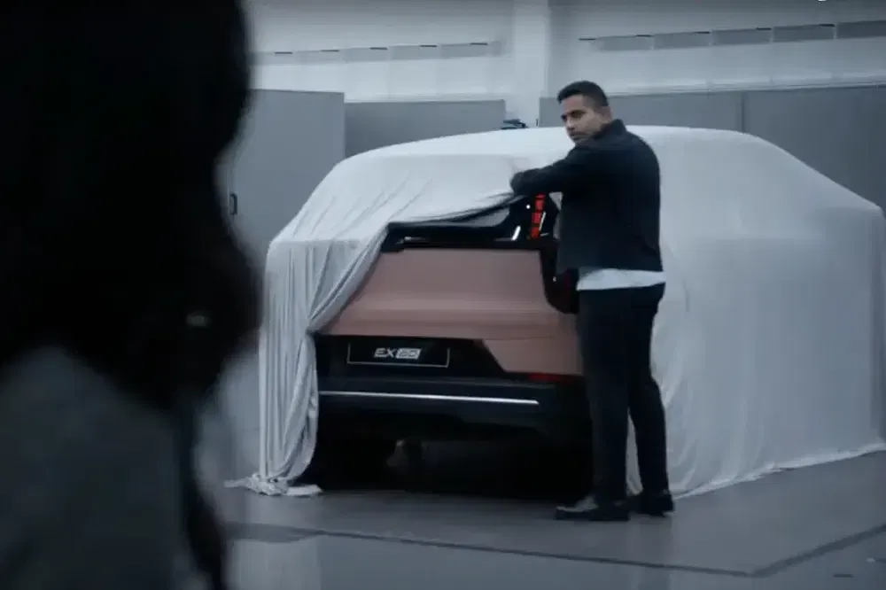 Man onthult een SUV EXEED EX80 in een moderne werkplaats.