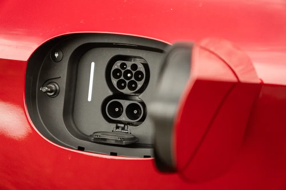 Port de charge d'une voiture électrique rouge avec connecteur compatible CCS Combo.