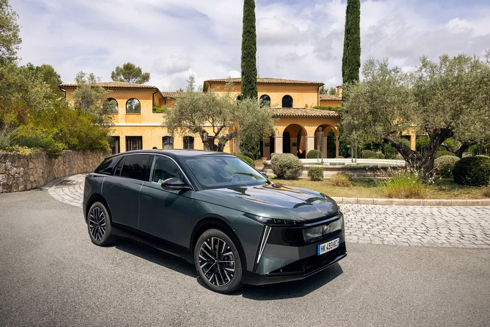 Elektrische Renault Scenic E-Tech voor een villa in mediterrane stijl met bomen.
