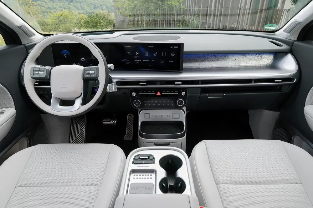 Intérieur moderne de la Hyundai Ioniq 5 avec tableau de bord numérique et sièges en tissu.