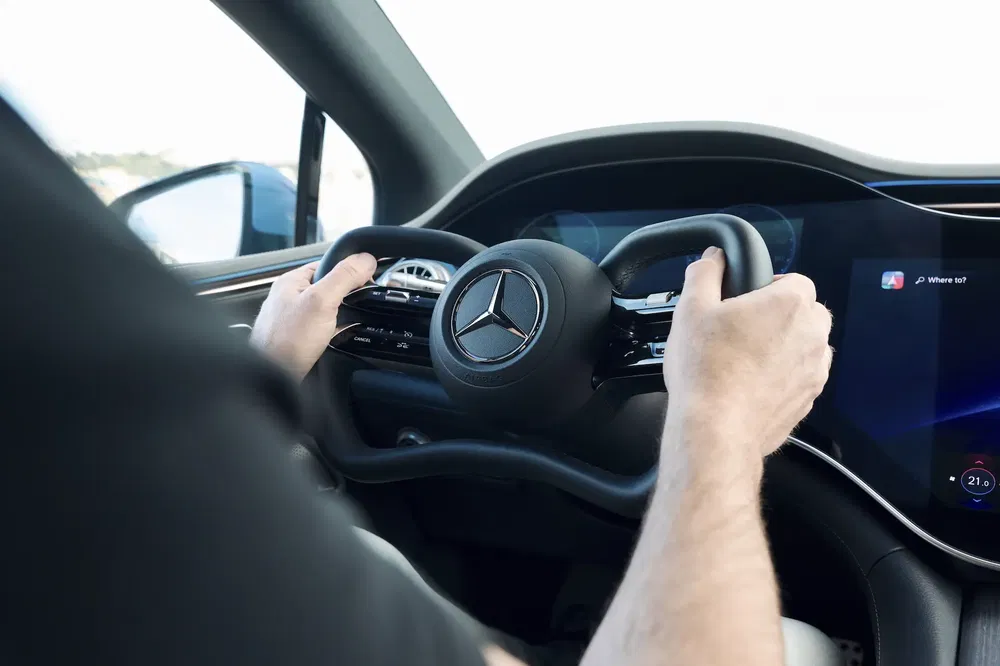 Futuristisch interieur van een Mercedes-Benz met innovatief stuur en digitaal touchscreen.