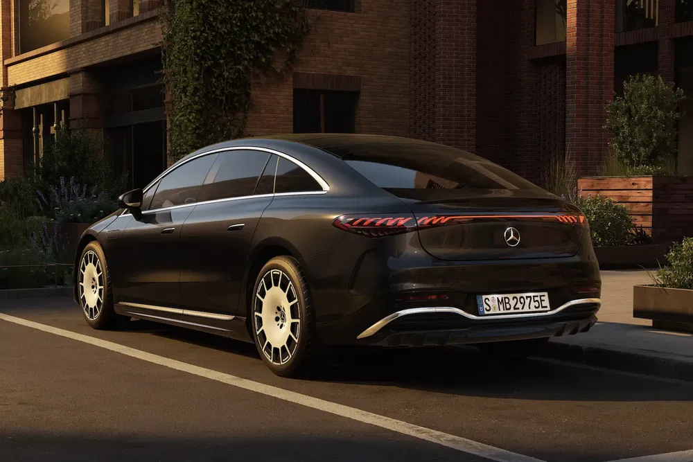 Mercedes-Benz EQS noir garée, design élégant, éclairage arrière distinctif, quartier urbain.