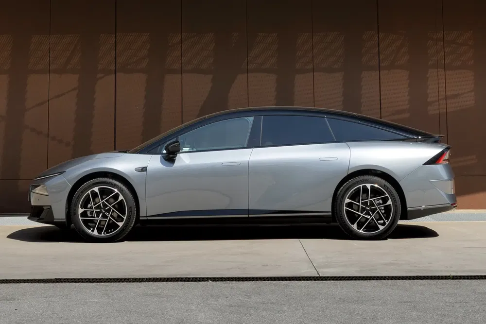 Profil latéral d'une voiture électrique élégante et futuriste, couleur argent métal.