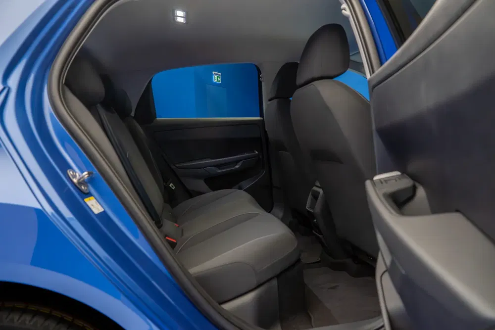Intérieur arrière spacieux d'une voiture électrique Skoda Enyaq avec sièges noirs élégants.