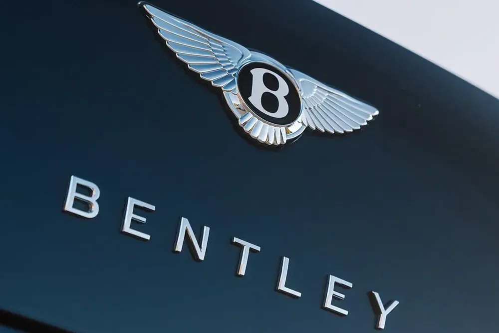 Logo Bentley avec ailes emblématiques sur fond noir élégant.
