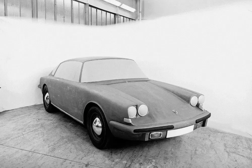 Prototype Porsche 911 en argile dans un atelier, design rétro des années 1960.