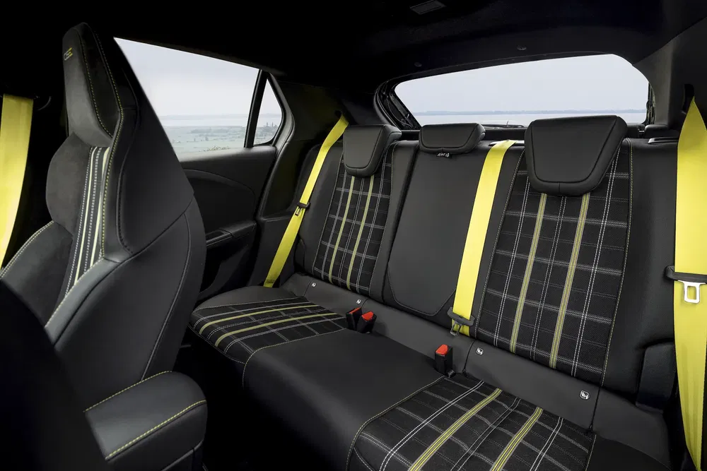 Intérieur arrière de Volvo performance avec ceintures de sécurité jaunes et sièges à motifs.