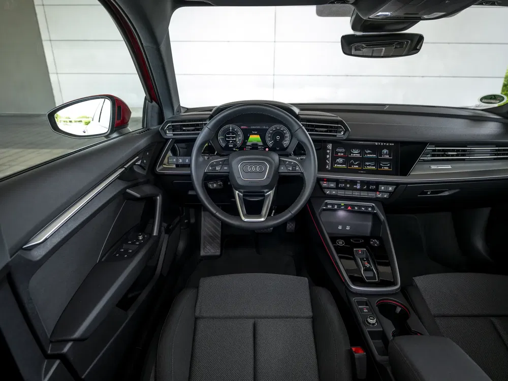 Intérieur moderne d'une Audi avec tableau de bord numérique et volant multifonction.