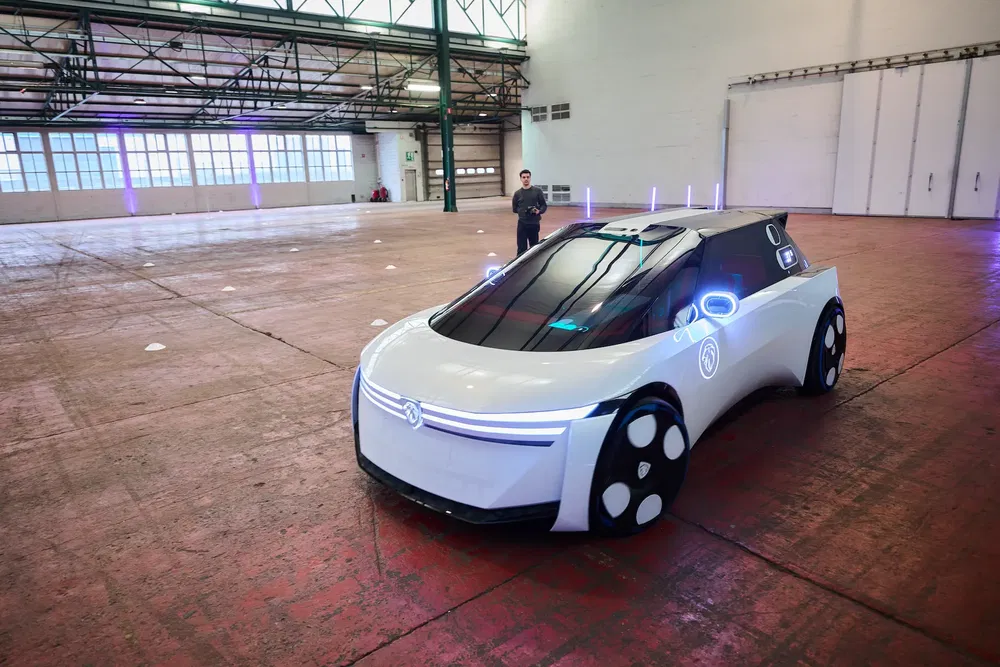 Concept car électrique Volkswagen avec éclairage LED dans un entrepôt spacieux.