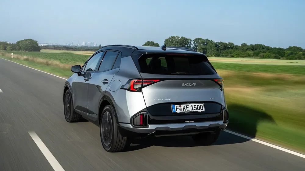 Kia Sportage 2023 roulant à grande vitesse sur une route de campagne dégagée.