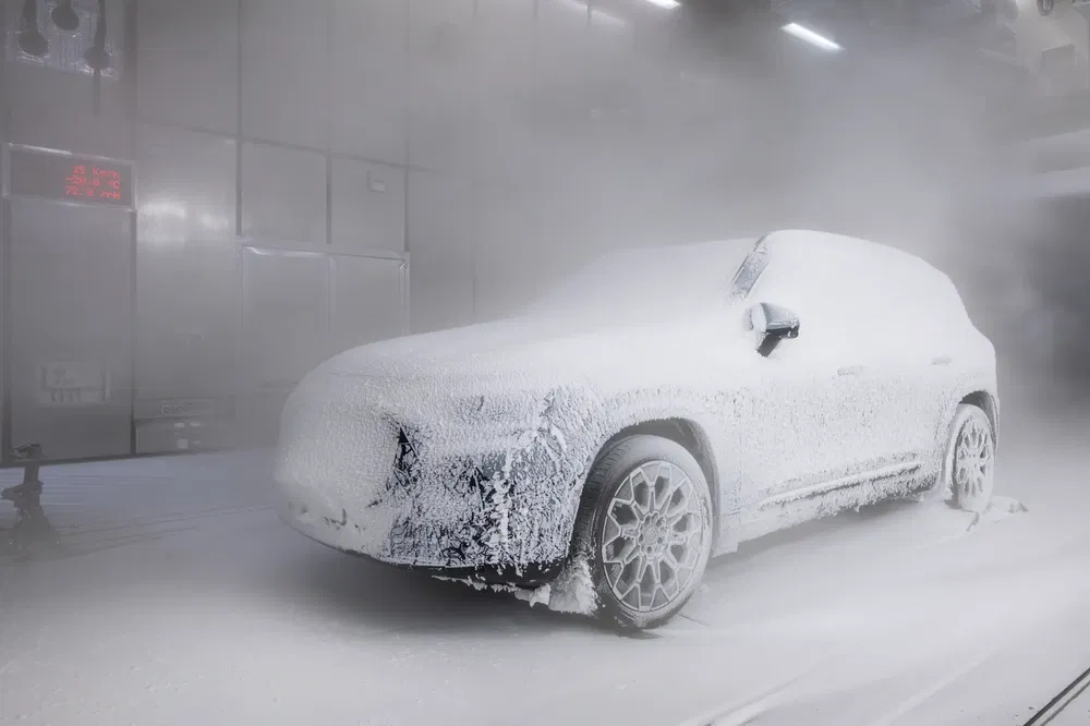 SUV sous neige artificielle lors d'un test de résistance au froid en laboratoire.