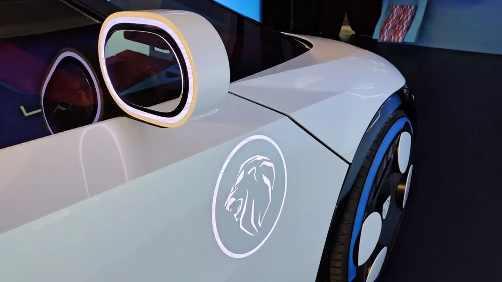 Concept-car Peugeot à design moderne et emblème lion sur la carrosserie blanche.