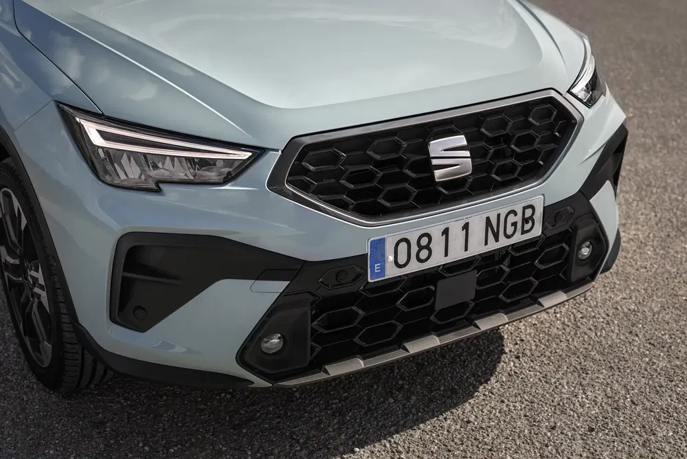 Close-up van SEAT-voorkant met honingraatgrille en Spaanse nummerplaat.