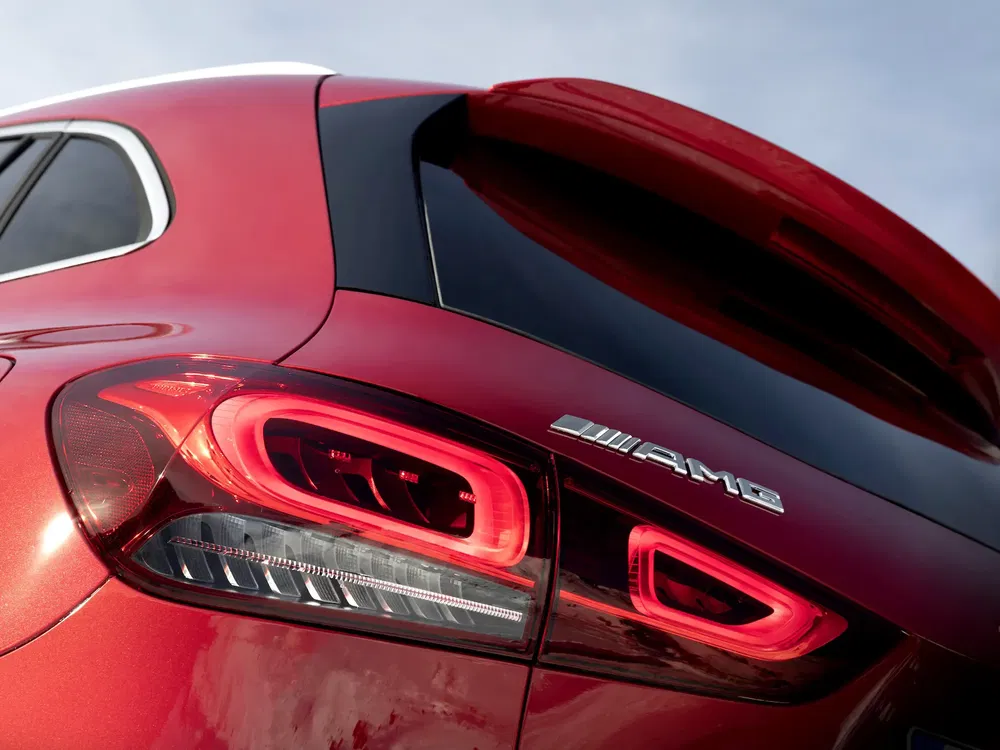 Feu arrière et logo AMG sur une Mercedes rouge, design sportif et moderne.