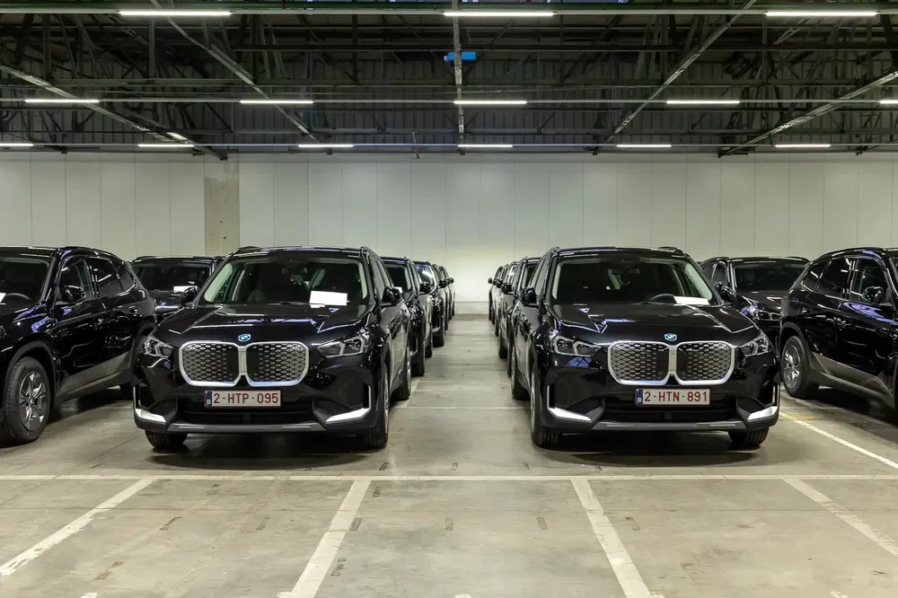 {"fr":"Rangée de BMW X5 noires dans un parking intérieur sous éclairage artificiel.","nl":"Rij zwarte BMW X5's op een binnenparkeerplaats onder kunstlicht."}
