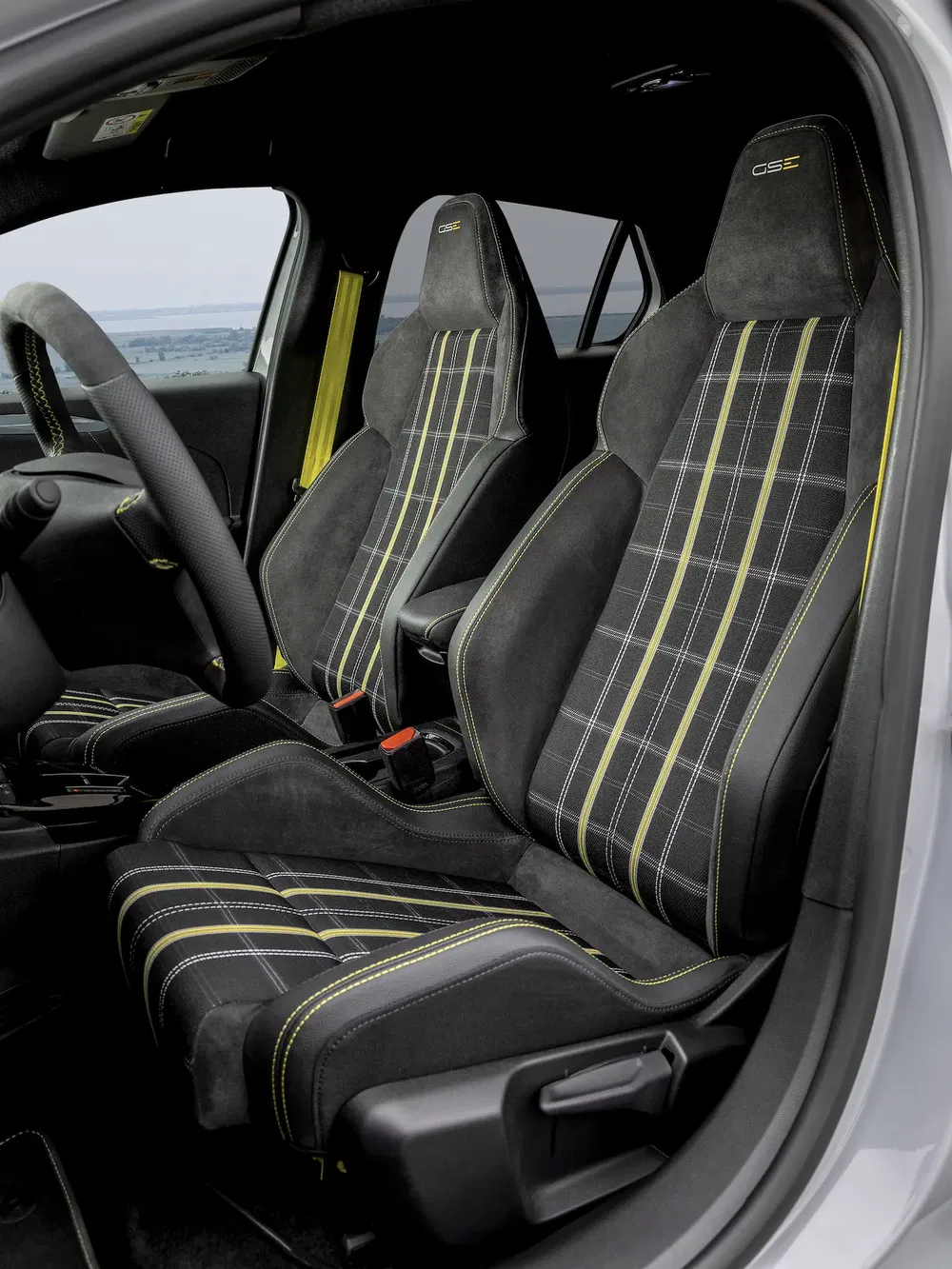 Intérieur d'une Opel avec sièges sport GSe en tissu à motifs noirs et jaunes.