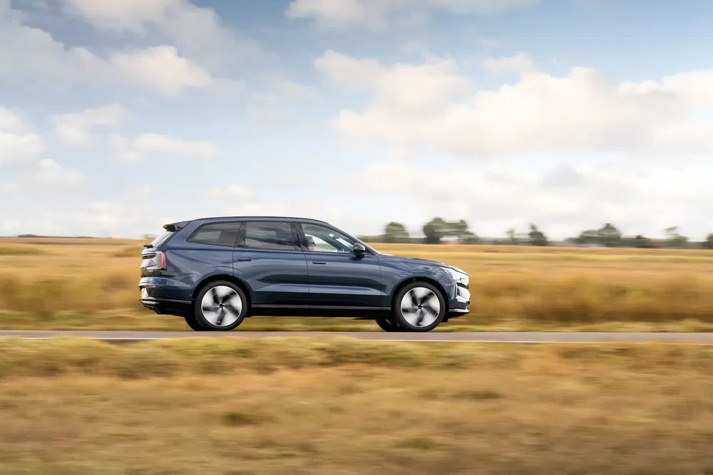 SUV Skoda roulant à grande vitesse sur une route rurale sous un ciel nuageux.