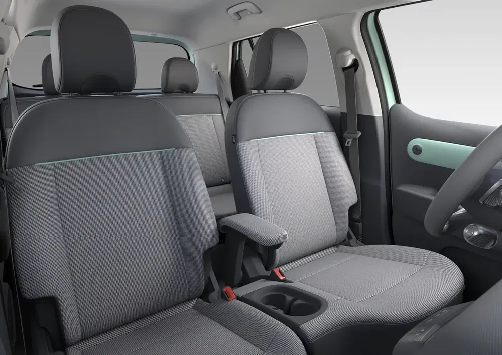 Moderne interieur van de Fiat Panda met ergonomische grijze stoelen en middenarmsteun.