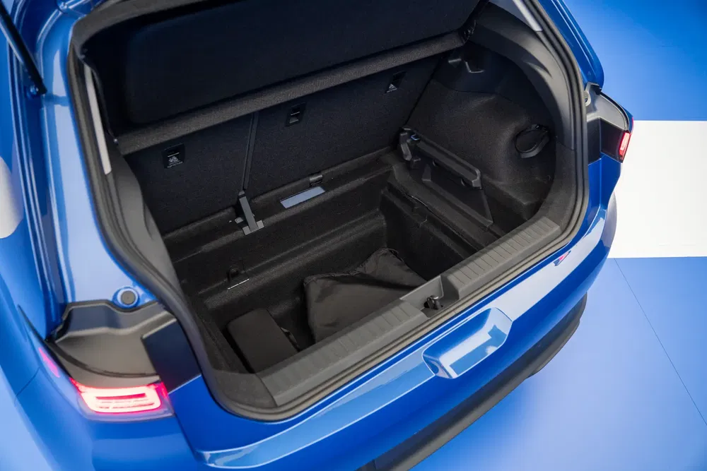 Coffre d'une voiture bleue moderne, spacieux avec des sièges arrière rabattables.