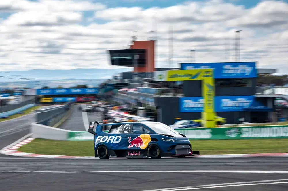 Ford-raceauto met Red Bull-logo op circuit, onscherpe achtergrond, bij bocht.