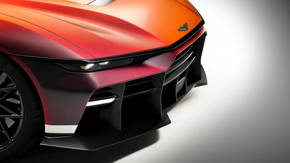 Avant d'une voiture sport Aston Martin avec peinture dégradée orange à rouge, design aérodynamique.