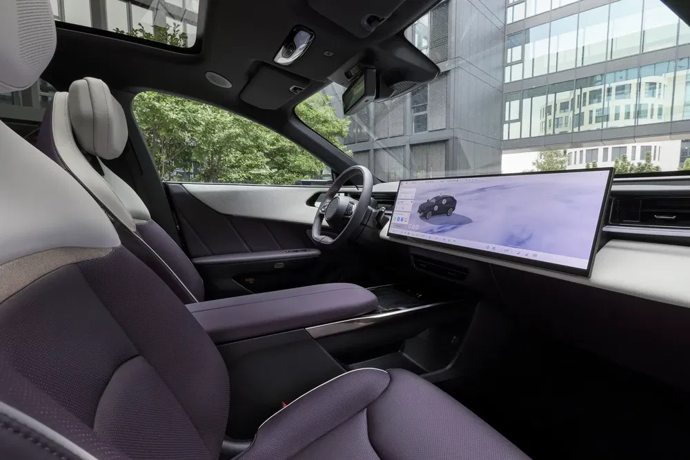 Intérieur moderne de voiture électrique avec tableau de bord numérique et sièges élégants.