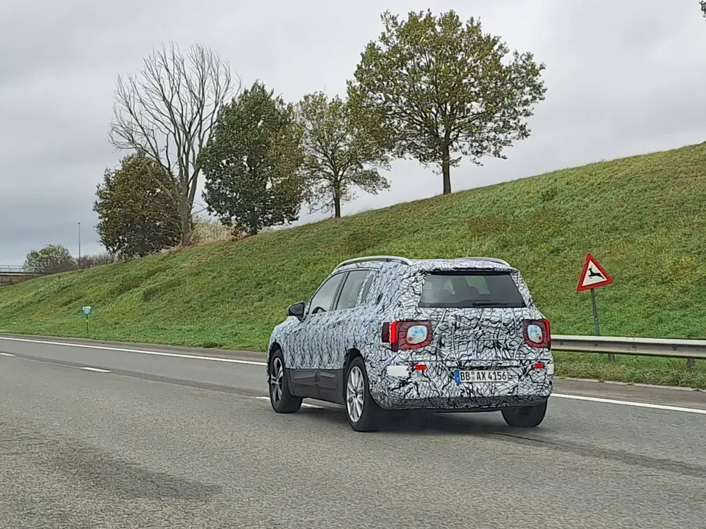 Prototype de voiture camouflée sur autoroute, probablement un SUV en phase de test.