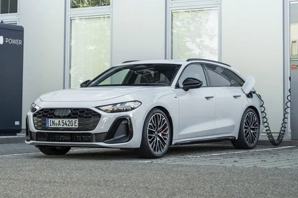 Witte Audi A6 Avant e-tron opgeladen bij een elektrische laadpaal.