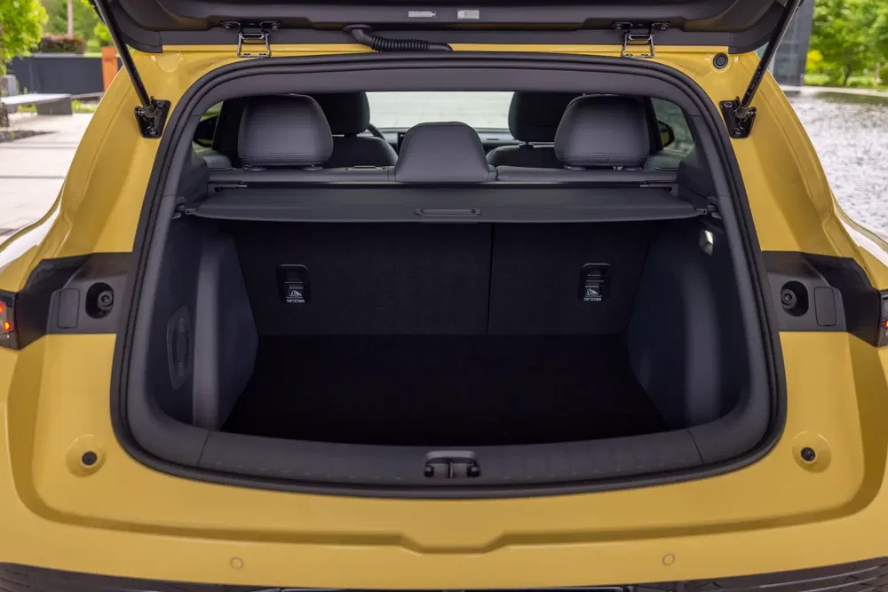 Coffre spacieux d'une voiture SUV jaune, prêt à transporter des bagages.