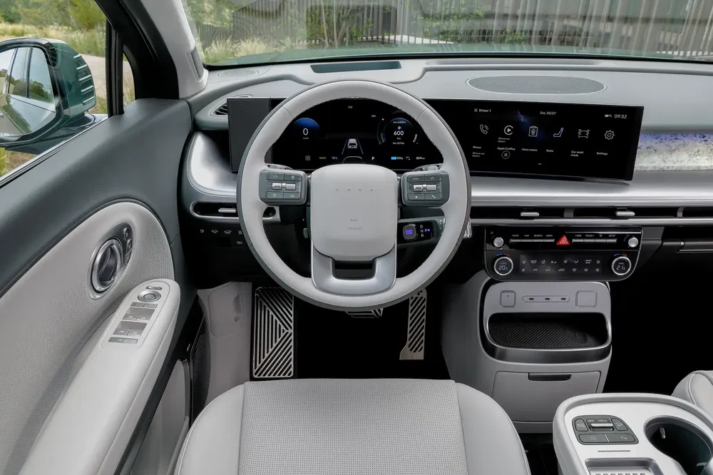 Intérieur moderne de la Hyundai Ioniq 5 avec tableau de bord numérique et volant innovant.
